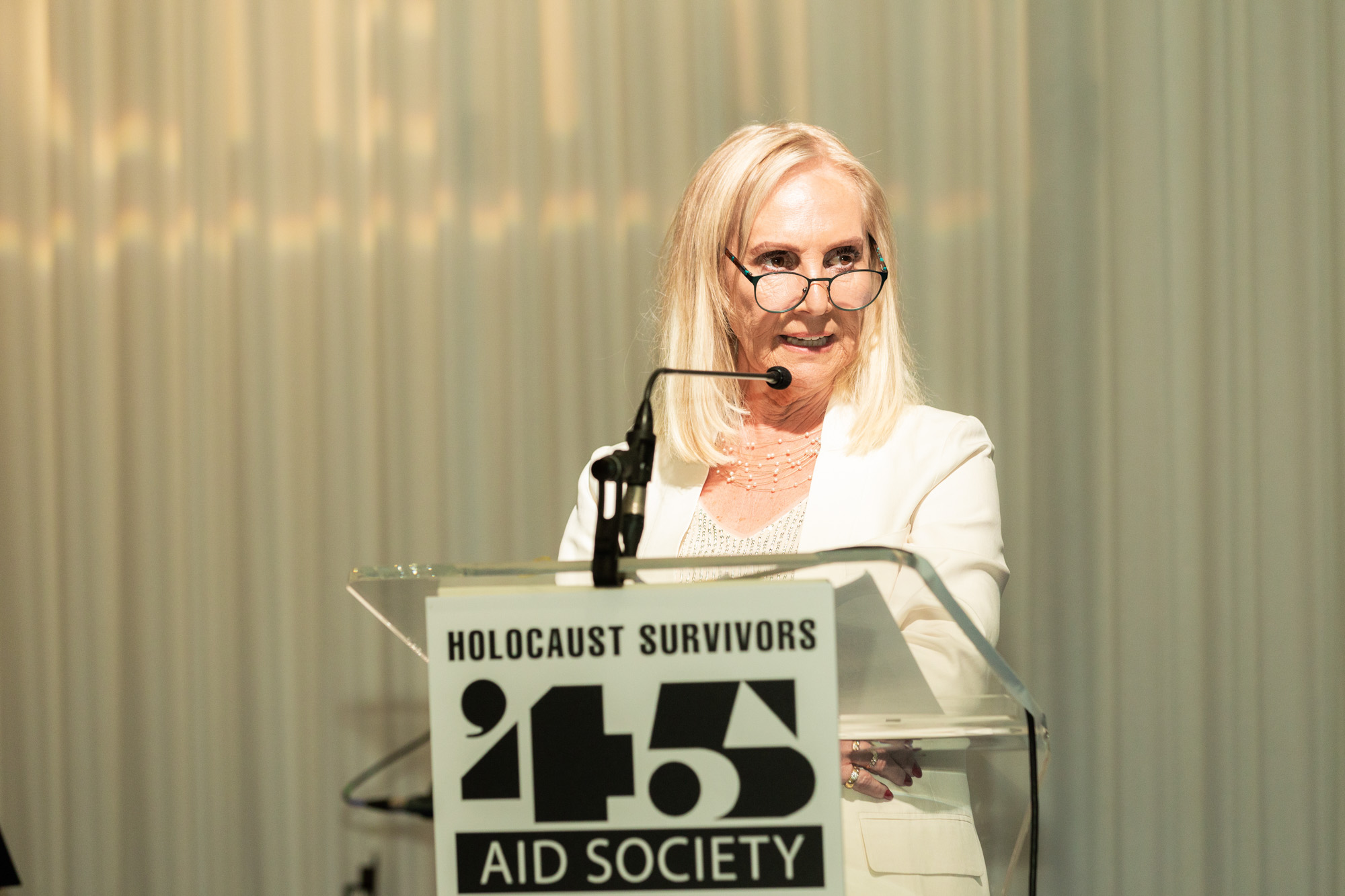 Photograph of Angela Cohen, President of the '45 Aid Sociey, addressine the 2022 Reunion.